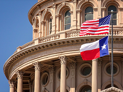 American and Texas state flags flying on the dome of the Texas State Capitol building in Austin Amendments to Texas UTSA Bring it Closer in Line with DTSA, but Differences Remain